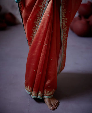 Rust orange half and half saree with sleeveless blouse