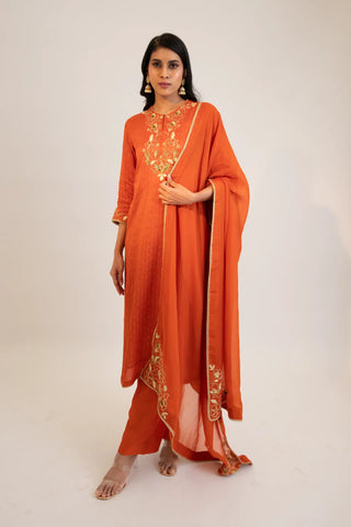 Rust embroidered straight kurta paired with pants and dupatta.