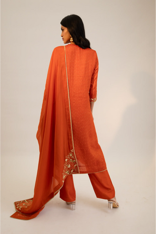 Rust embroidered straight kurta paired with pants and dupatta.